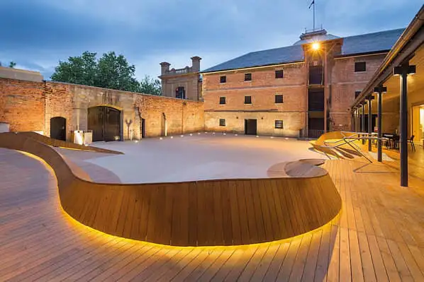 The wooden courtyard of the Tasmanian Museum and Art gallery framed in golden lighting.
